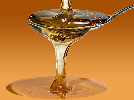 photo of honey-like liquid pour into and over a spoon