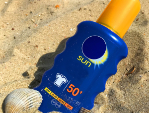 photo of sunscreen bottle on the beach