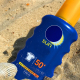 photo of sunscreen bottle on the beach